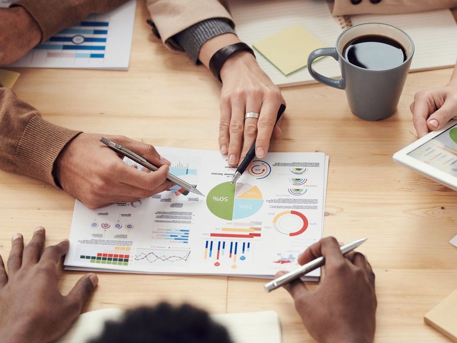 Hands over printed charts, pens and a tablet
